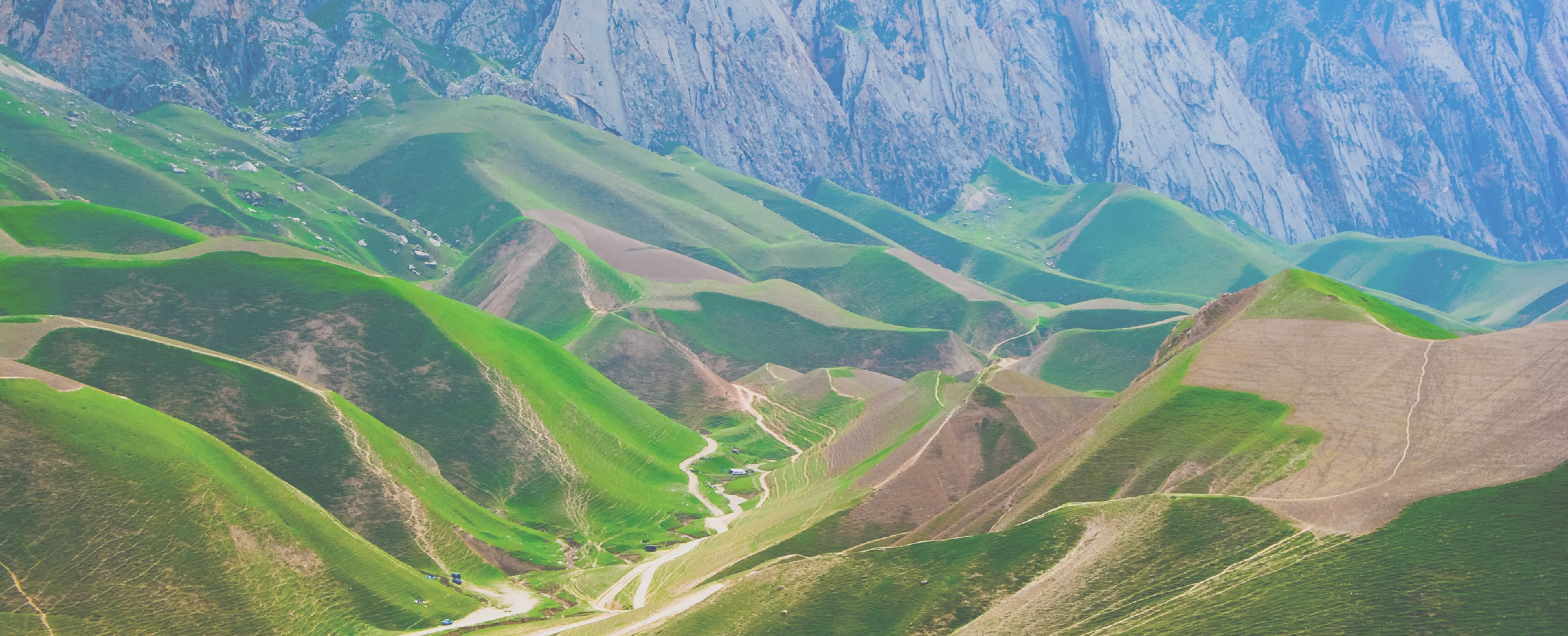 Green terraced hills below a limestone ridge in Afghanistan
